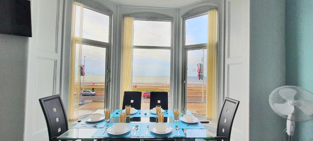 Charlton Aparthotel في بلاكبول: غرفة طعام مع طاولة وكراسي ونافذة