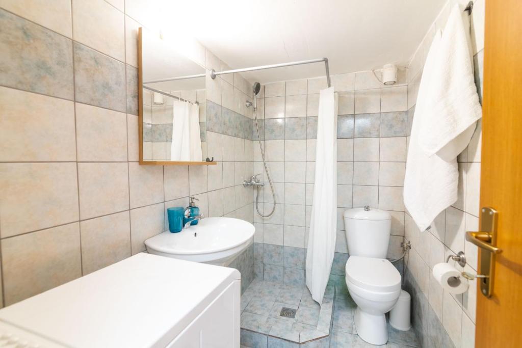un bagno bianco con un water e un lavandino di F & B Summer Collection - Kassandra - Siviri a Siviri