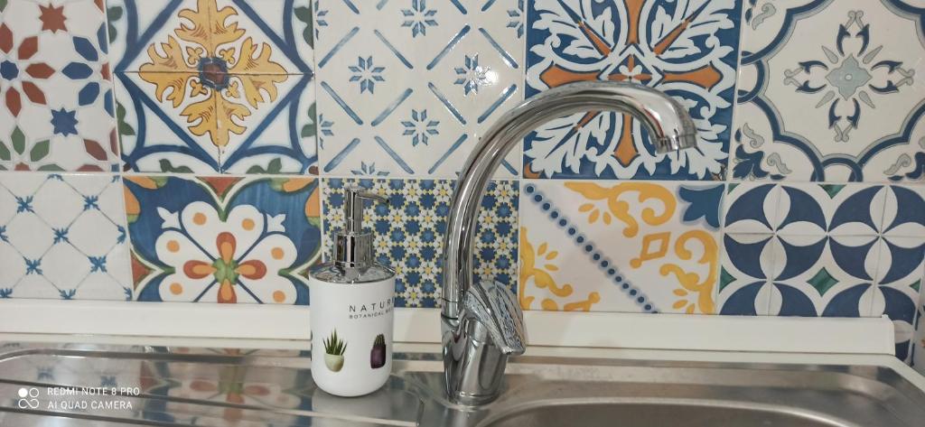 a kitchen sink with a faucet and some tiles at Casa Annita, casa vacanza in stile Sicilia, in pieno centro a Pachino in Pachino