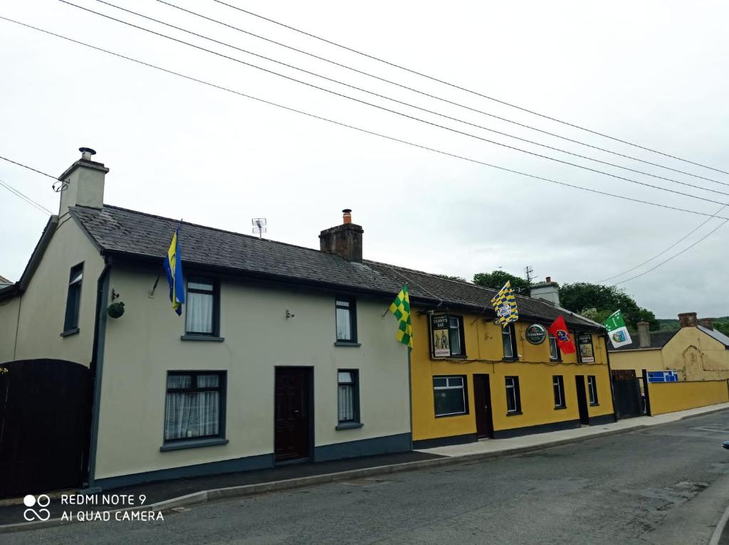 a row of yellow and white buildings on a street at Danny's Bar Restaurant & accommodation in Broadford