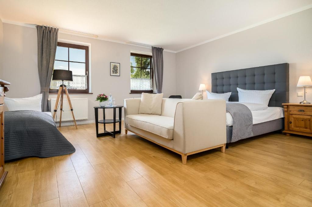 um quarto com uma cama, um sofá e uma cadeira em Residenz am Ostufer em Boek