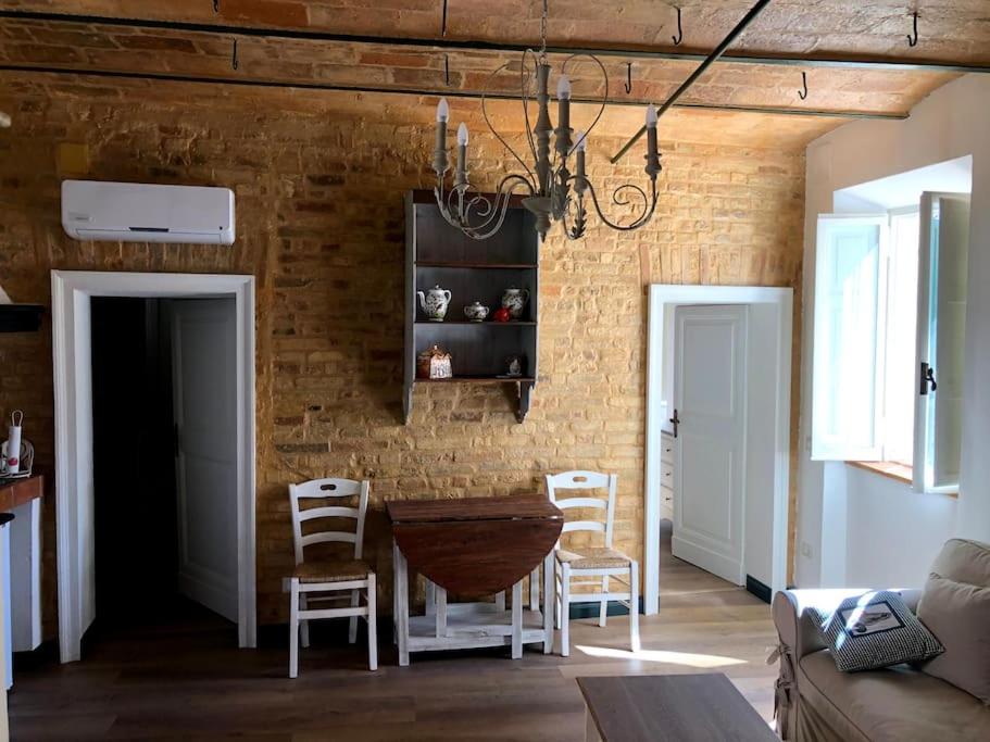 salon z drewnianym stołem i krzesłami w obiekcie Casa Rosy nel centro del borgo di Patrignone w mieście Patrignone