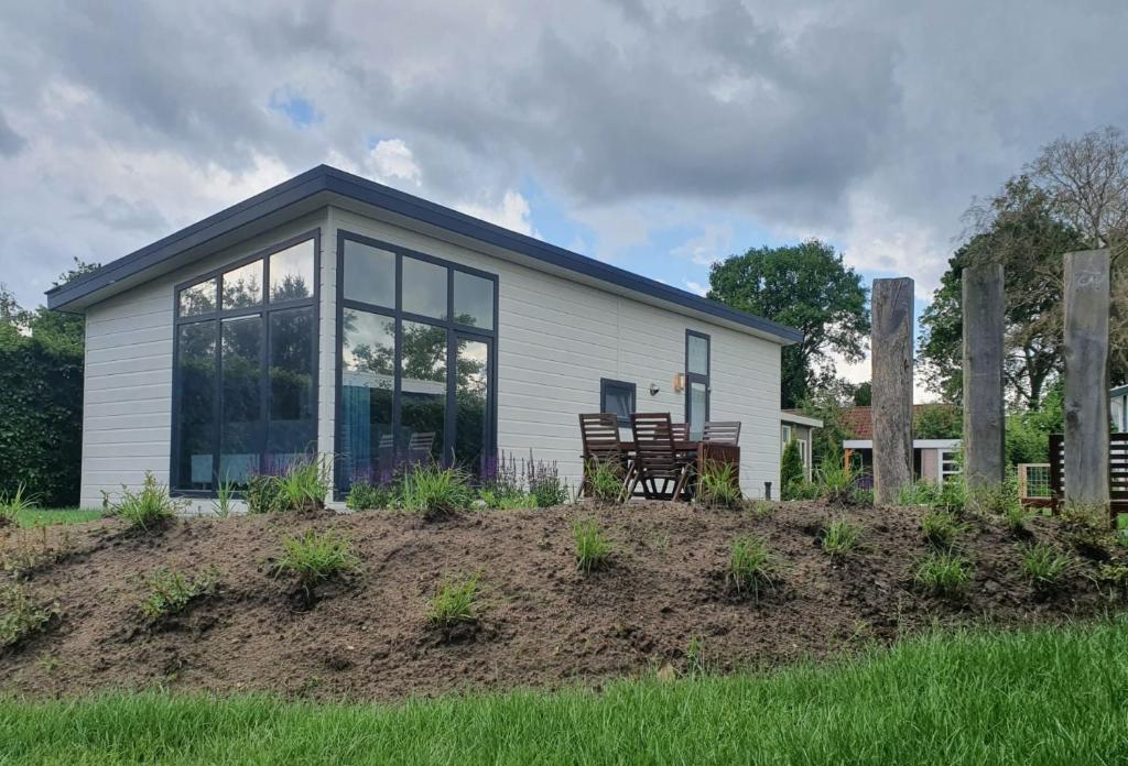 a small white house with a large window at Klein Ramdal in Putten