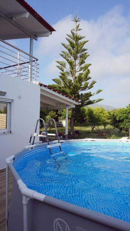 a large swimming pool with a tree in the background at Villa Liostasi in Lagolíon