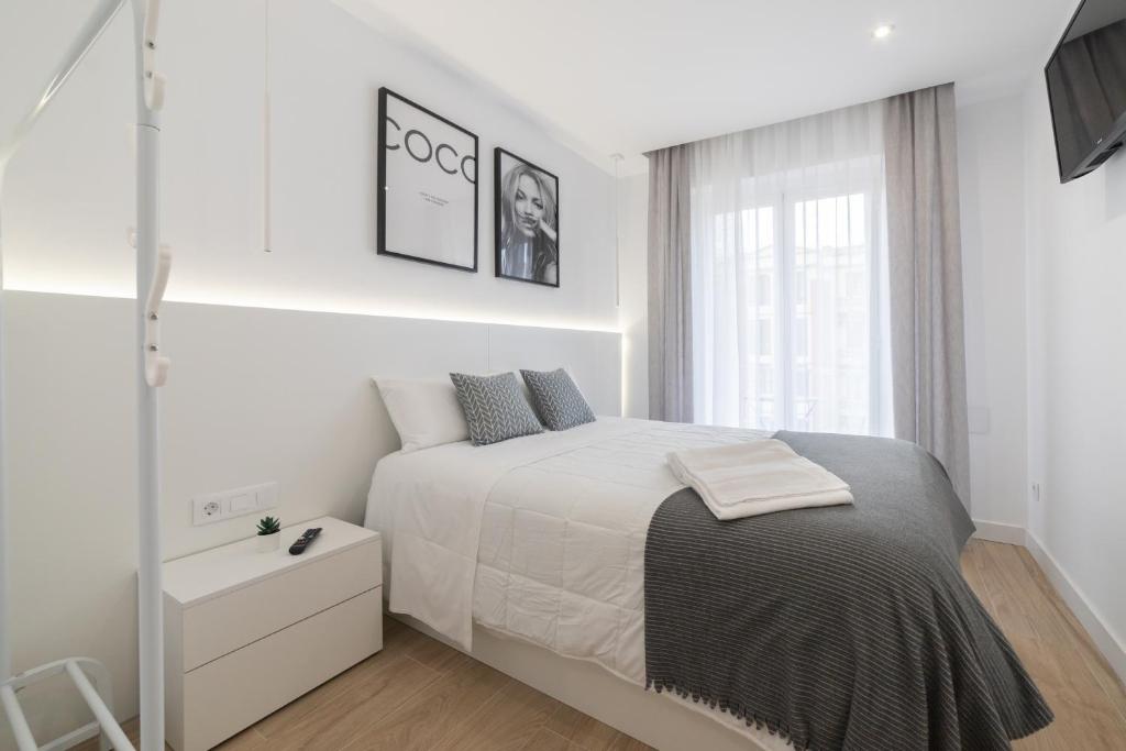 a white bedroom with a bed and a window at Apartamento Logroño Plaza Ayuntamiento in Logroño
