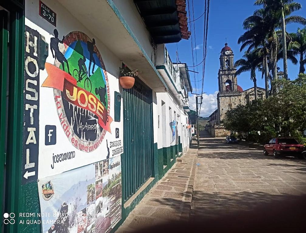 un edificio con una señal en el costado con una torre de reloj en Hostal Donde Jose en Guadalupe