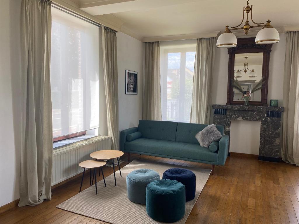 KortessemにあるHuis Louisのリビングルーム(青いソファ、スツール付)