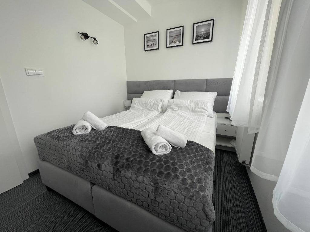 a bedroom with a bed with towels on it at Apartament Planeta Mielno 115 Premium in Mielno