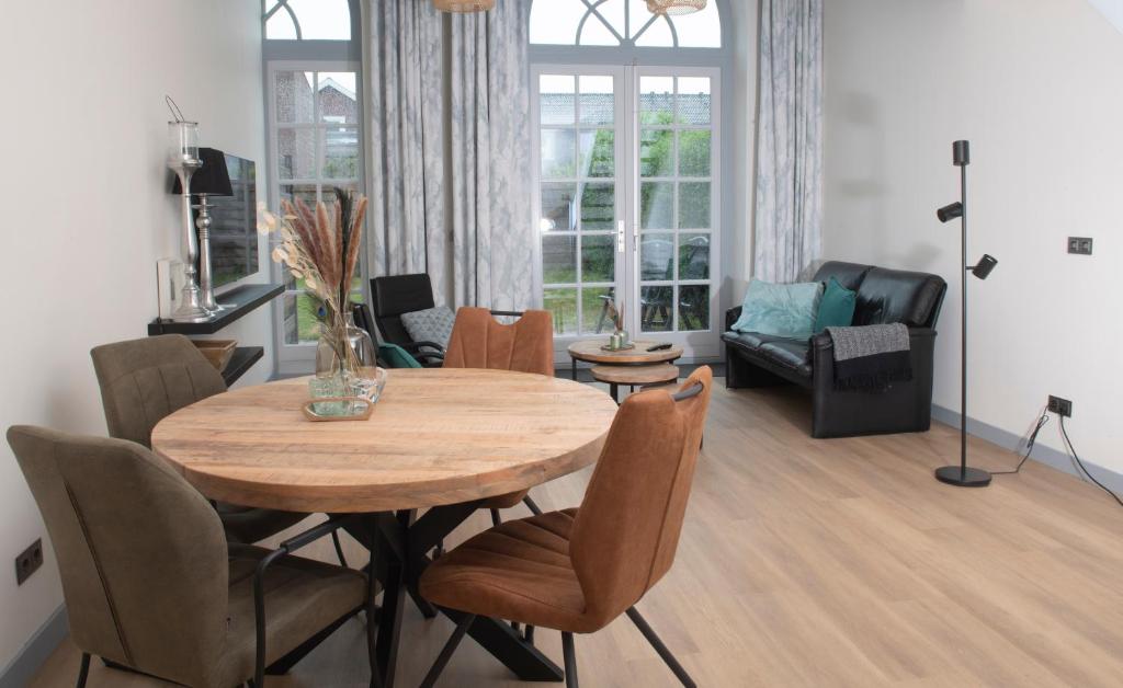 een woonkamer met een houten tafel en stoelen bij Texbed in Den Burg