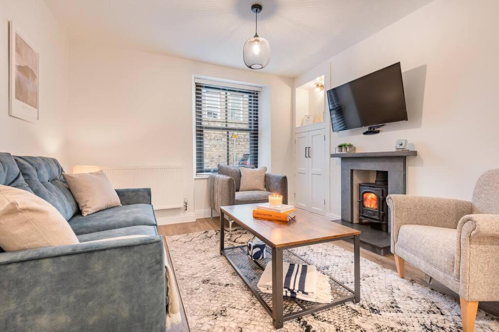 a living room with a couch and a fireplace at Carpenters Cottage - The Lakes! in Kendal