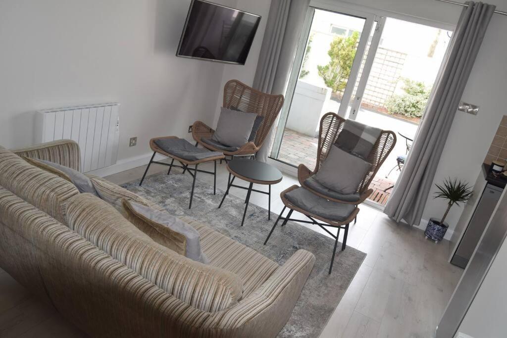 a living room with a couch and chairs and a television at 2 bed Apartment Ballycastle Seconds to Seafront in Ballycastle