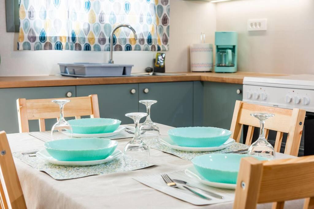 伊斯特隆的住宿－Thèros garden，一张桌子,上面有蓝色的盘子和玻璃杯