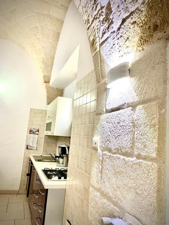 a kitchen with a stone wall and a counter top at LA PICCOLA DIMORA in Carovigno