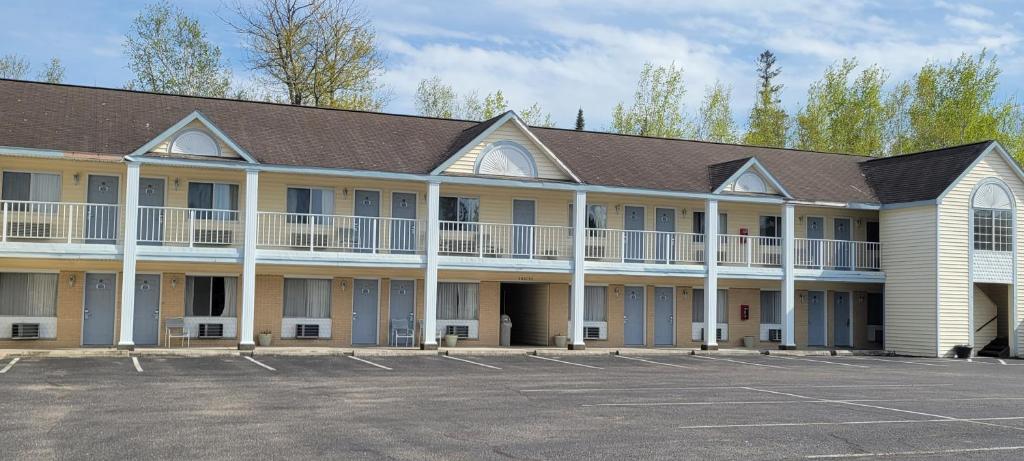 an exterior view of a hotel with a parking lot at Thunderbird Inn of Mackinaw City in Mackinaw City