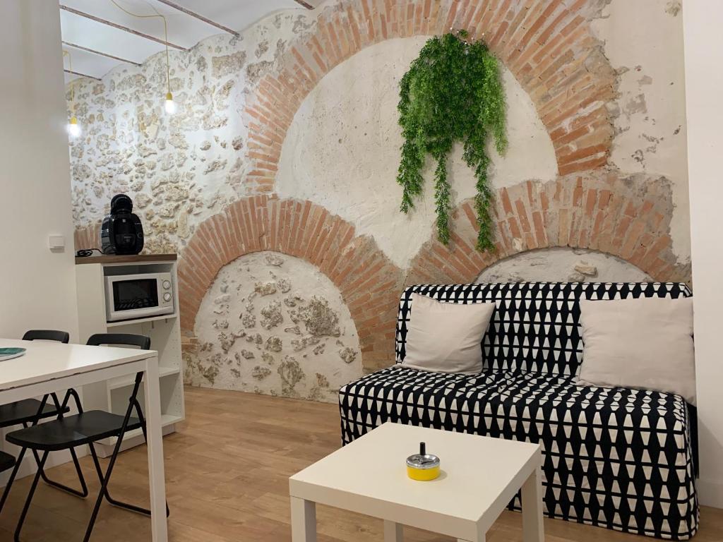 un salon avec un canapé et un mur de briques dans l'établissement A 2 PAS DU VIEUX PORT Charmant T2, à Marseille