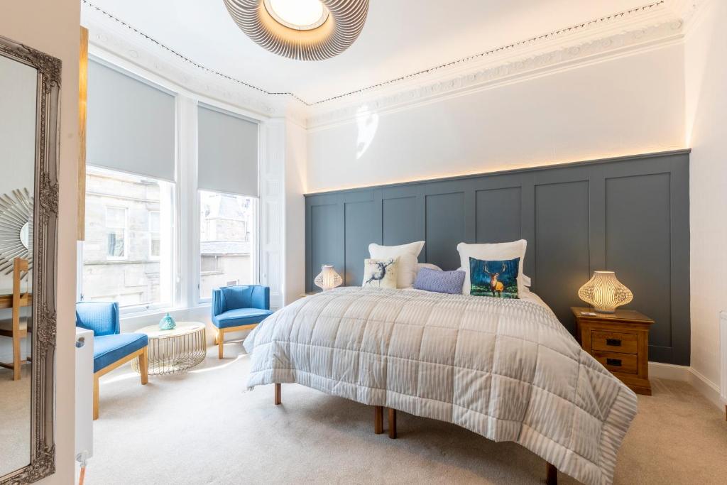 a bedroom with a large bed and blue walls at Annandale Guest House in St Andrews