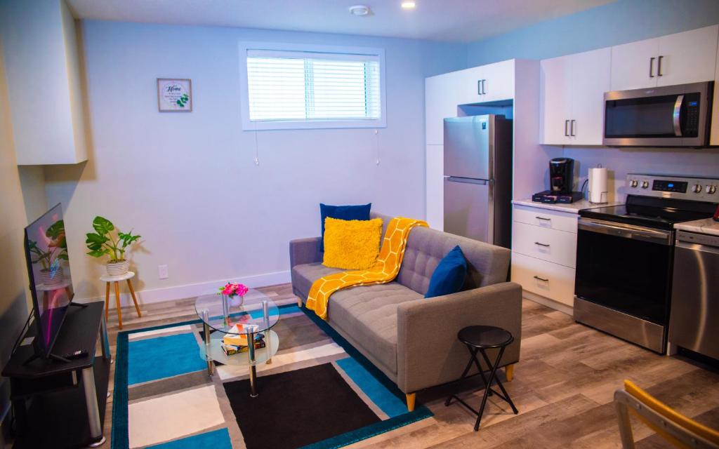 a living room with a couch and a kitchen at AIR & ROAD TRAVELERS' PERFECT SPOT! + FULL KITCHEN in Regina