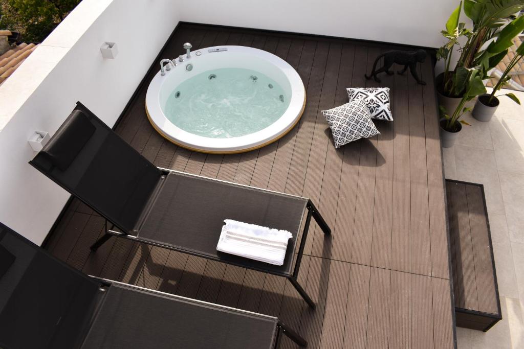 bañera de hidromasaje en una terraza con 2 sillas en SCIABICA SUITE - Sicilian Experience, en Favara
