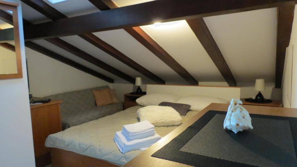 1 dormitorio con 1 cama y 1 mesa con libros en Apartments Maričić Rab Island, en Rab
