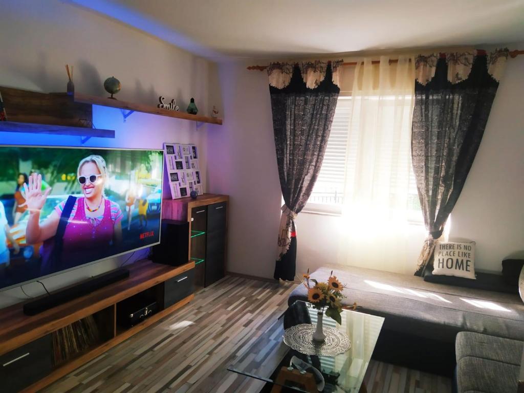 ein Wohnzimmer mit einem Flachbild-TV und einem Sofa in der Unterkunft Braavos Apartment 2 - Šibenik city center in Šibenik