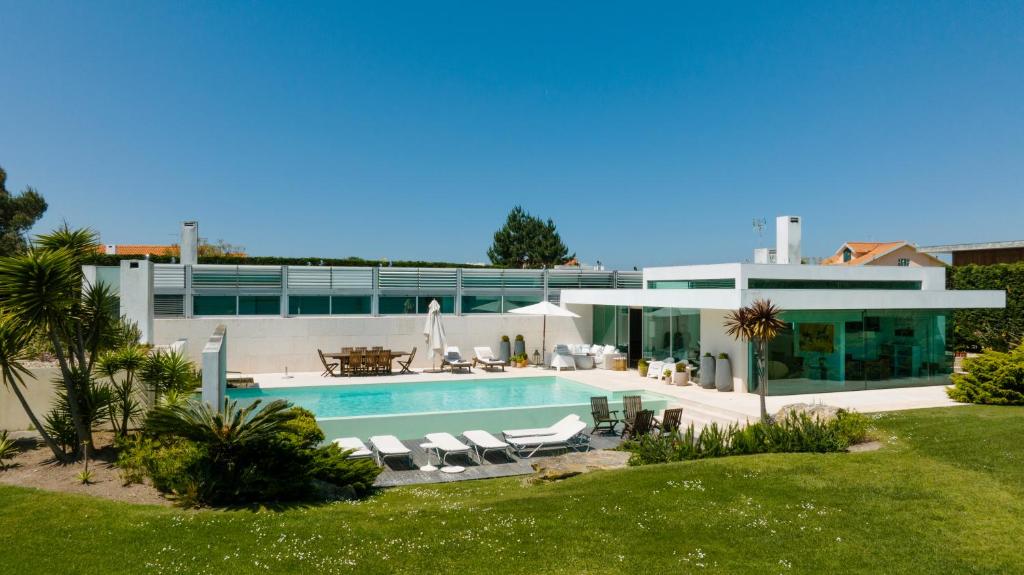 una casa grande con piscina frente a ella en Casa da Ria, en Torreira