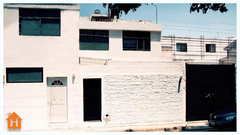 een wit gebouw met een witte deur aan de zijkant bij Cozy Apartment close to Andares @serra in Guadalajara