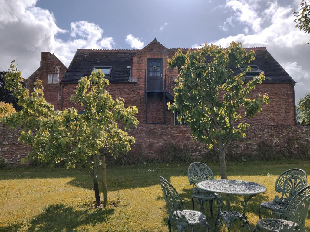 Una mesa y sillas frente a un edificio. en The Coach House, en Bridgwater