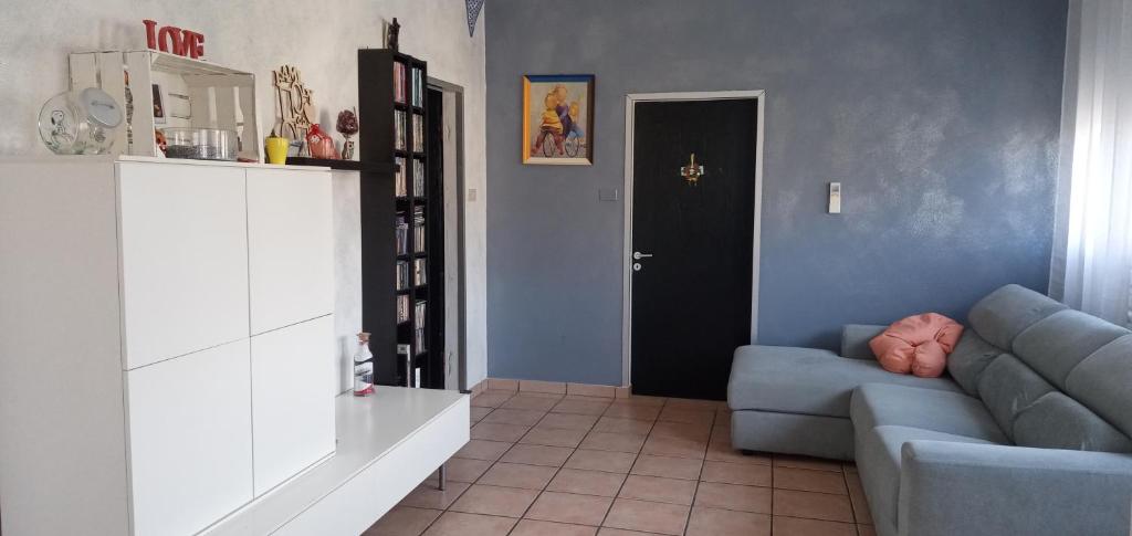 sala de estar con sofá azul y puerta negra en locazione mimosa con giardino, en Ostellato