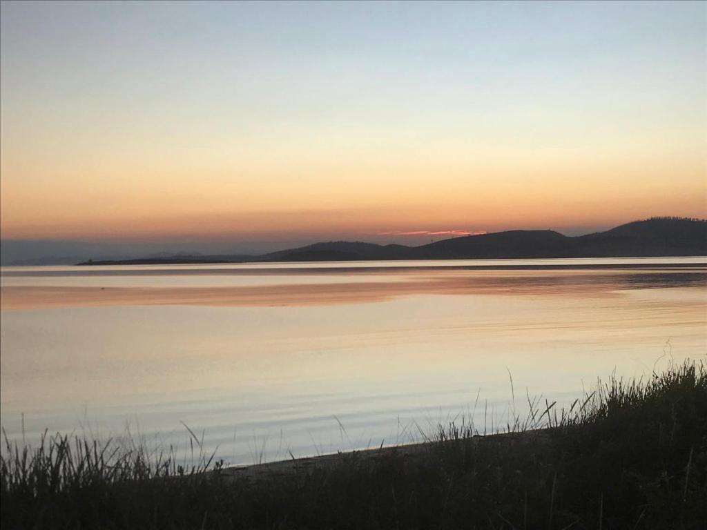 a sunset over a body of water with mountains in the background at Winganah Cottage in Murdunna