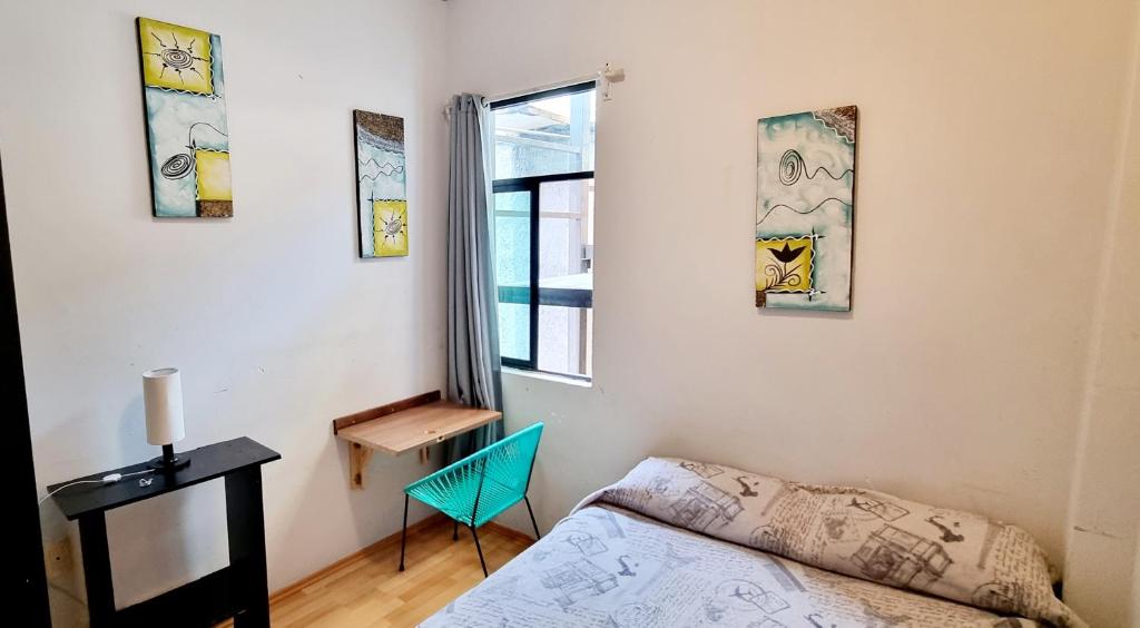 een slaapkamer met een bed, een bureau en een raam bij HOM Roma in Mexico-Stad