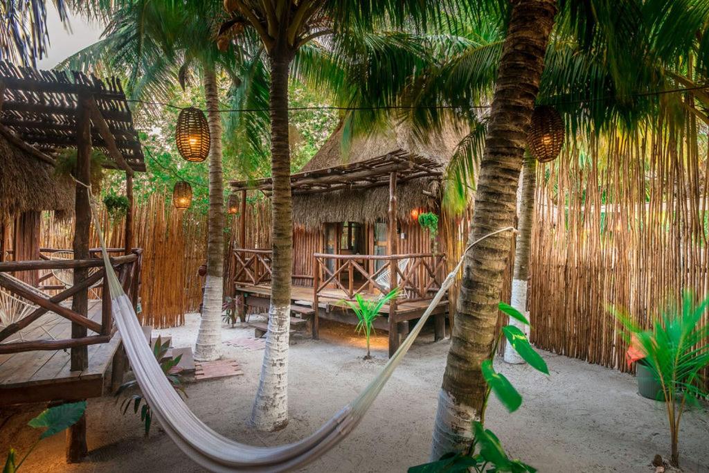 una hamaca frente a un complejo con palmeras en Eco Cabañas Laak Holbox - Adults Only - Self Check In en Holbox Island