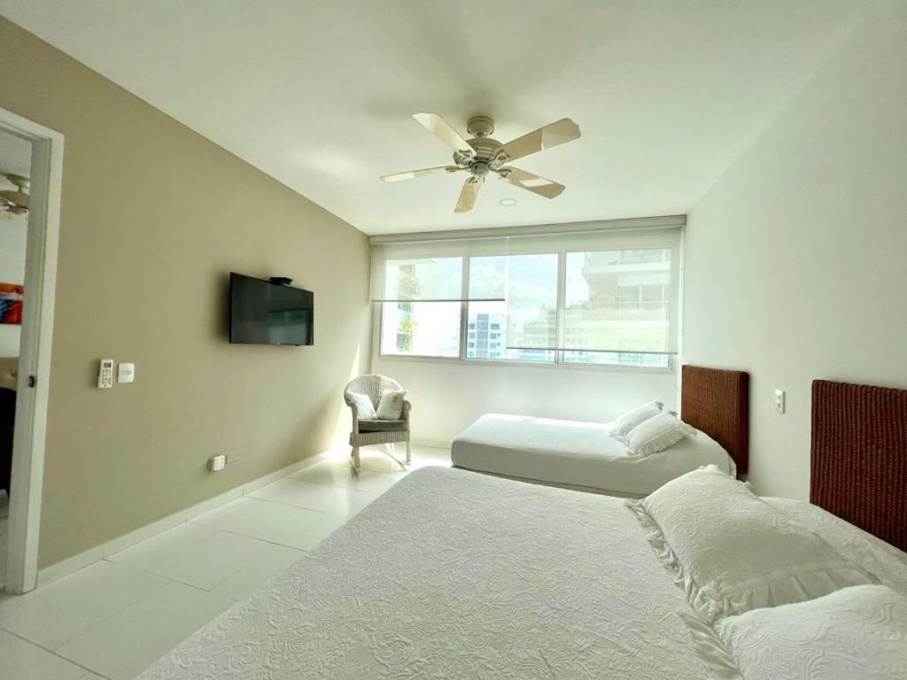 une chambre avec deux lits et un ventilateur de plafond dans l'établissement Hermoso apartamento familiar /acceso directo a la playa. Morros 3, à Carthagène des Indes