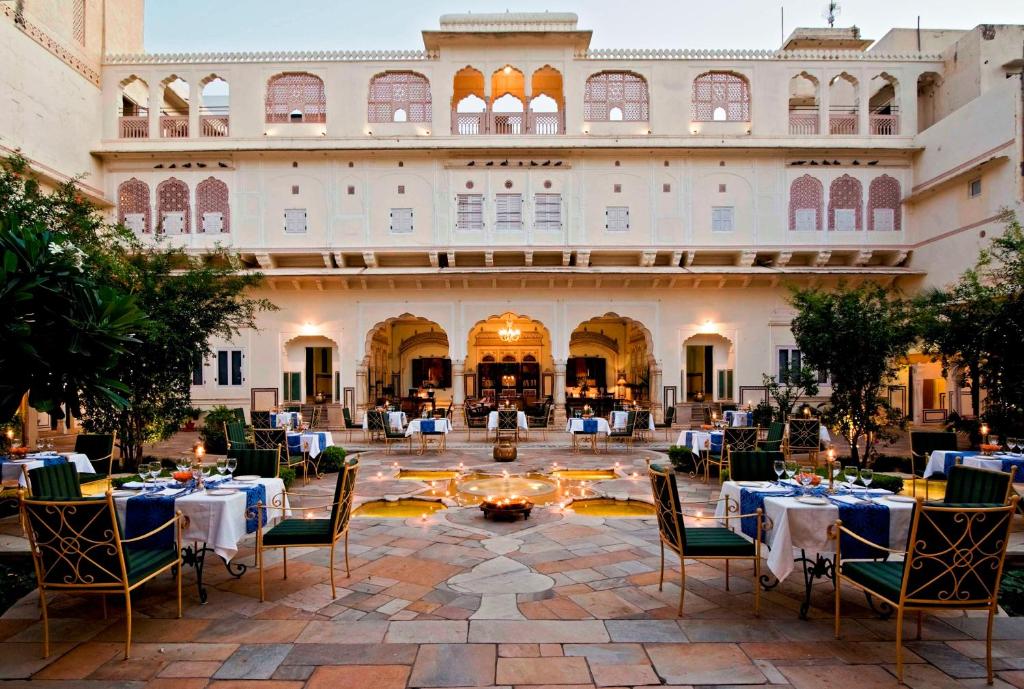 a view of the courtyard of a hotel with tables and chairs at Samode Haveli in Jaipur