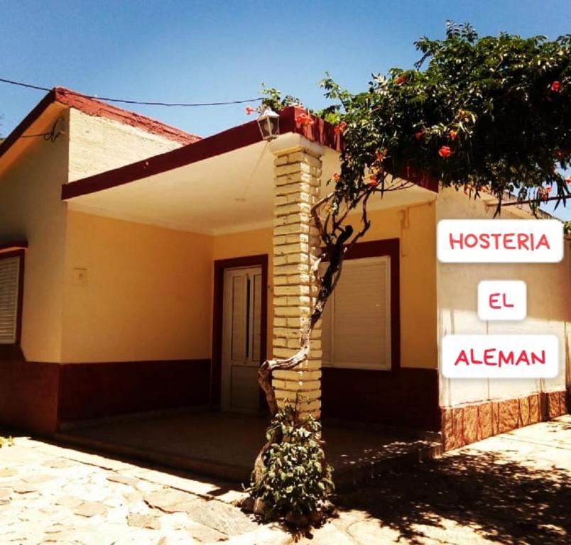 a house with a sign on the side of it at Hostería El Alemán in Cosquín