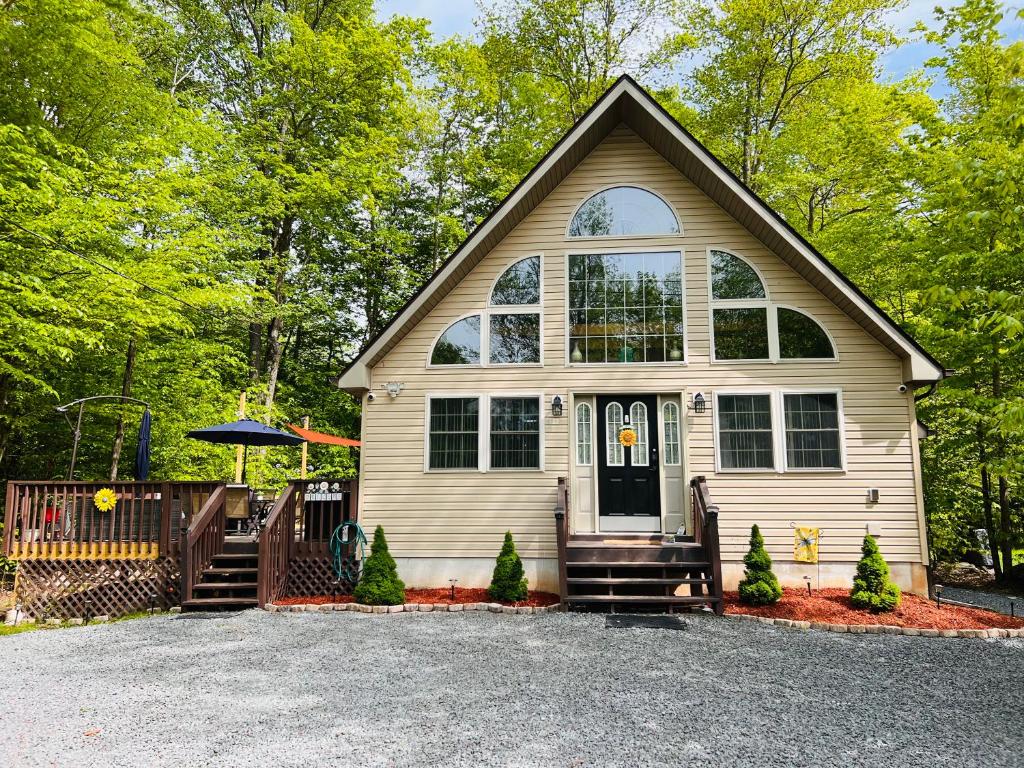 a small white house with a large window at Nature Escape Resort With Large Private Deck, Hot Tub, BBQ Grills, at Arrowhead Lake with 3 Pools, 4 Beaches at the Lakes and MORE in Thornhurst