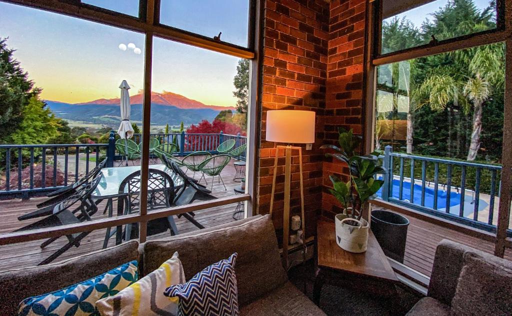 a living room with a balcony with a view of the mountains at Myee Alpine Retreat in Mount Beauty