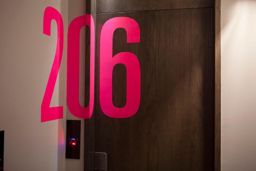 a large pink sign on a wooden door at TOC Hostel Barcelona in Barcelona
