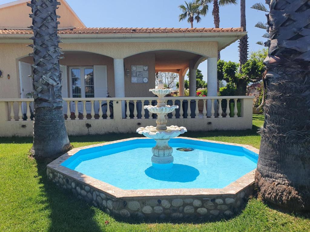 a fountain in the yard of a house at Villa les palmiers -Stretta di i mandarini in Lucciana