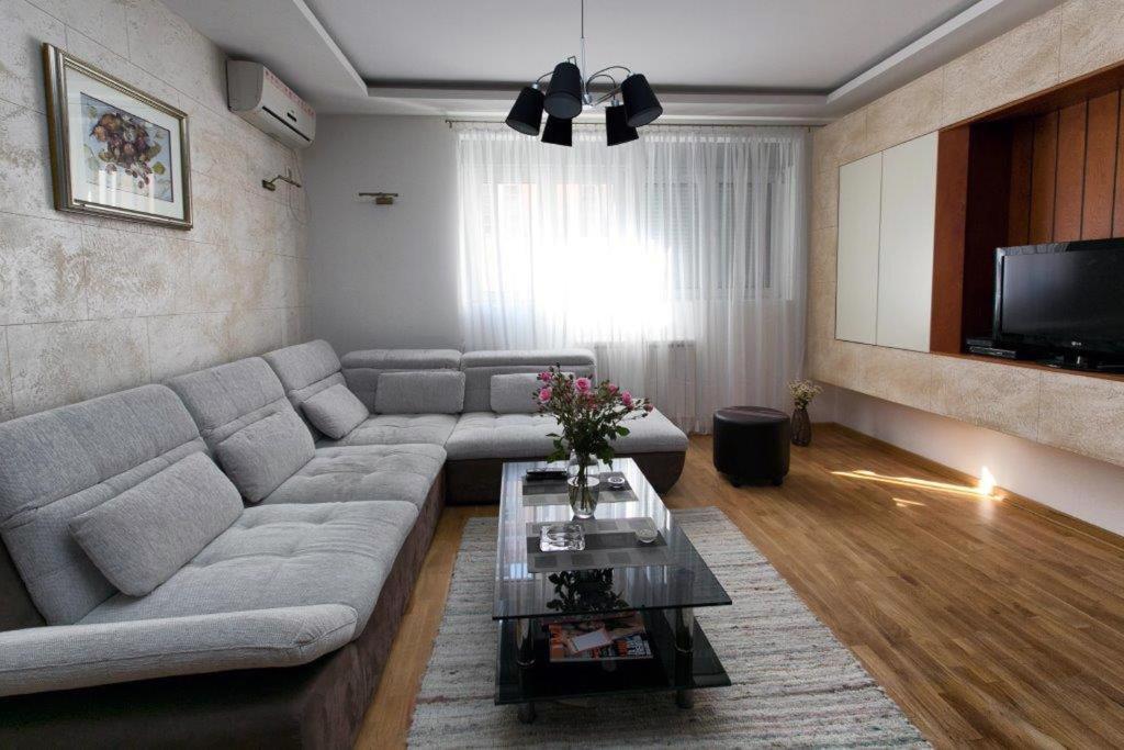 salon z kanapą i stołem w obiekcie Apartment 32 w Belgradzie