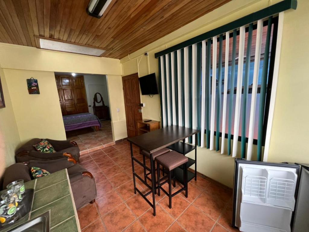 a living room with a table and a couch at Apartamento Sol Azul a 3 min del Aeropuerto SJO in Alajuela