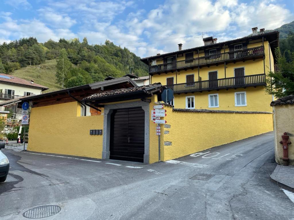 a yellow building on the side of a street at Appartamento Alessio in Ledro
