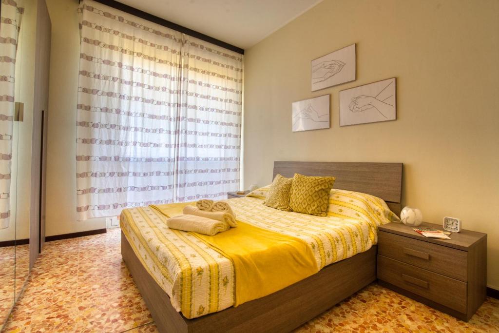 um quarto com uma cama grande e uma janela em CaseOspitali - CASA LUCE a due passi dal SAN RAFFAELE - 1 bedroom e divano in soggiorno em Vimodrone