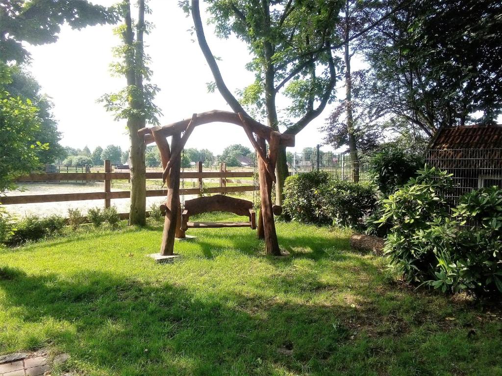 una panchina di legno nell'erba di un campo di Ranchhouse Hunde und Pferde willkommen ad Aurich