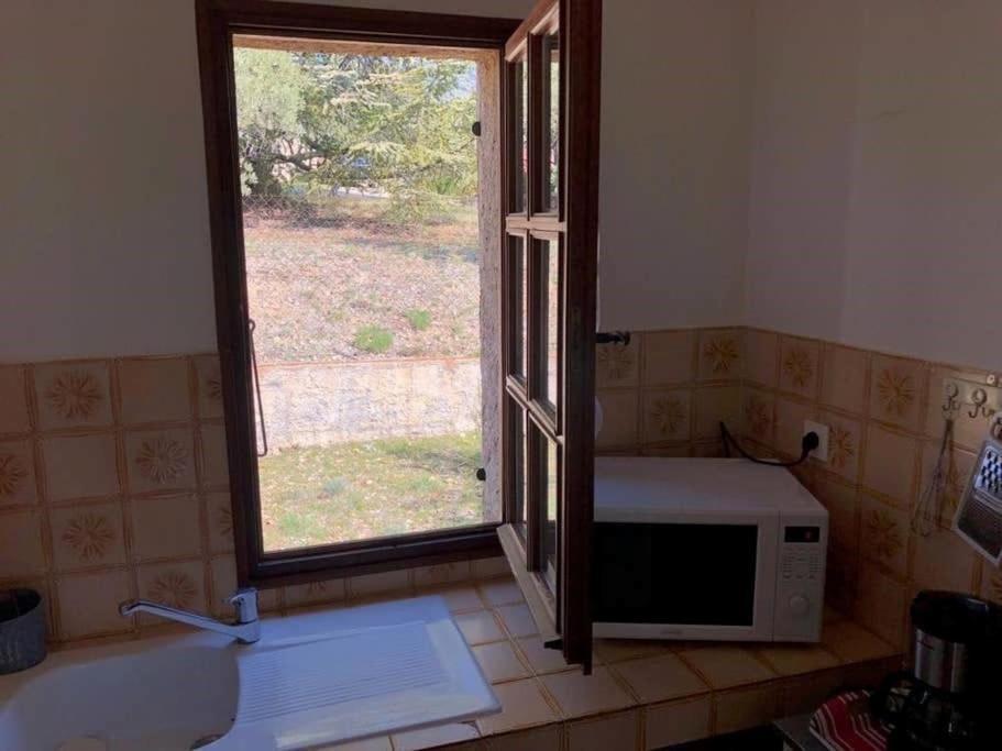 a kitchen with a microwave and a window at Résidence Lou Cigaloun - ANA LOCATION in Gréoux-les-Bains
