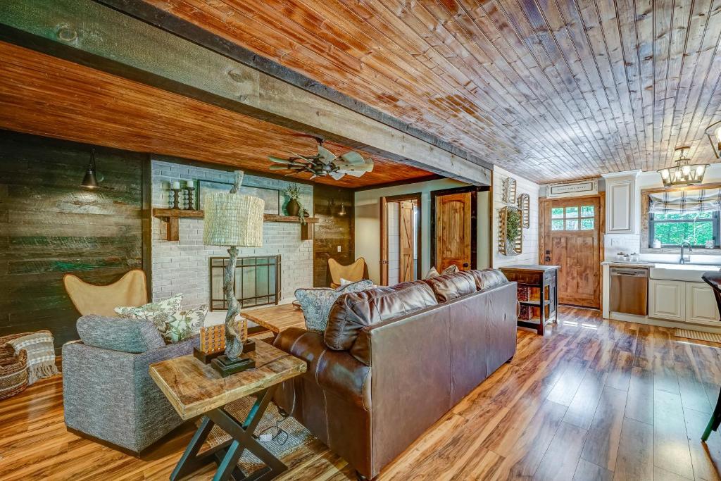 a living room with a leather couch and a table at Rustic Oasis in Ellijay