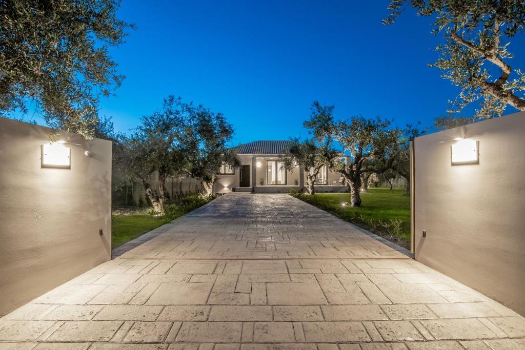 uma entrada vazia que leva a uma casa com árvores em Green Herbs Villa em Kalamaki