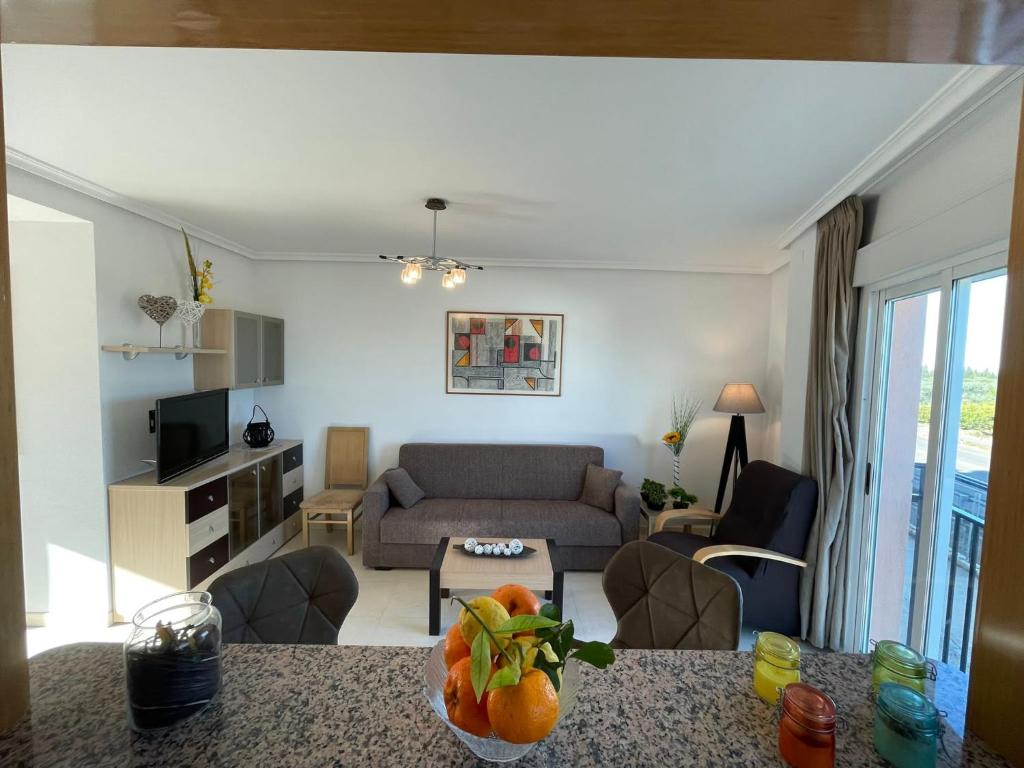 - un salon avec un canapé et une table dans l'établissement Apartamento en La Ribera de Cabanes/Marina D´or., à La Estación