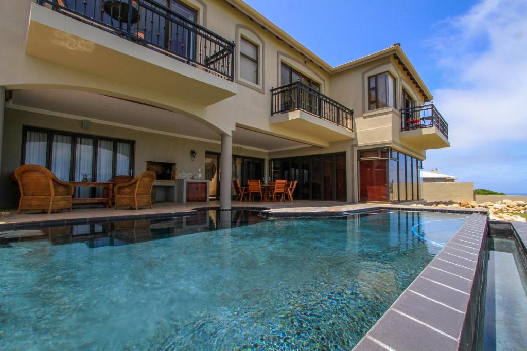 a swimming pool in front of a house at Two Sunsets B&B in Outeniqua Strand