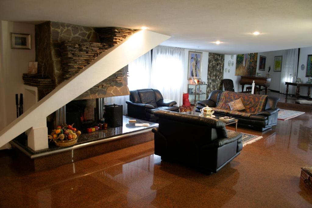 a living room with a fireplace and a couch and chairs at B&B Cà d'Artisti in Caorle