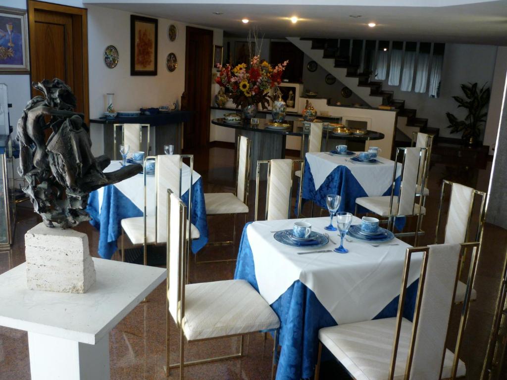 a dining room with white tables and chairs and a staircase at B&B Cà d'Artisti in Caorle